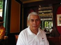 A man in white shirt sitting at table.