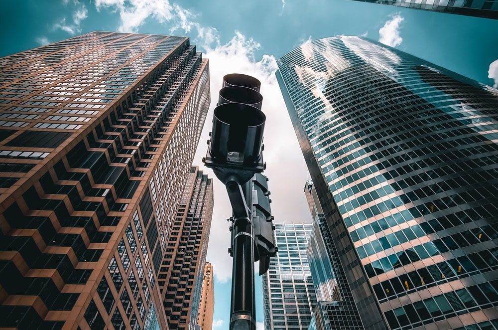 A view of some tall buildings from below the street light.