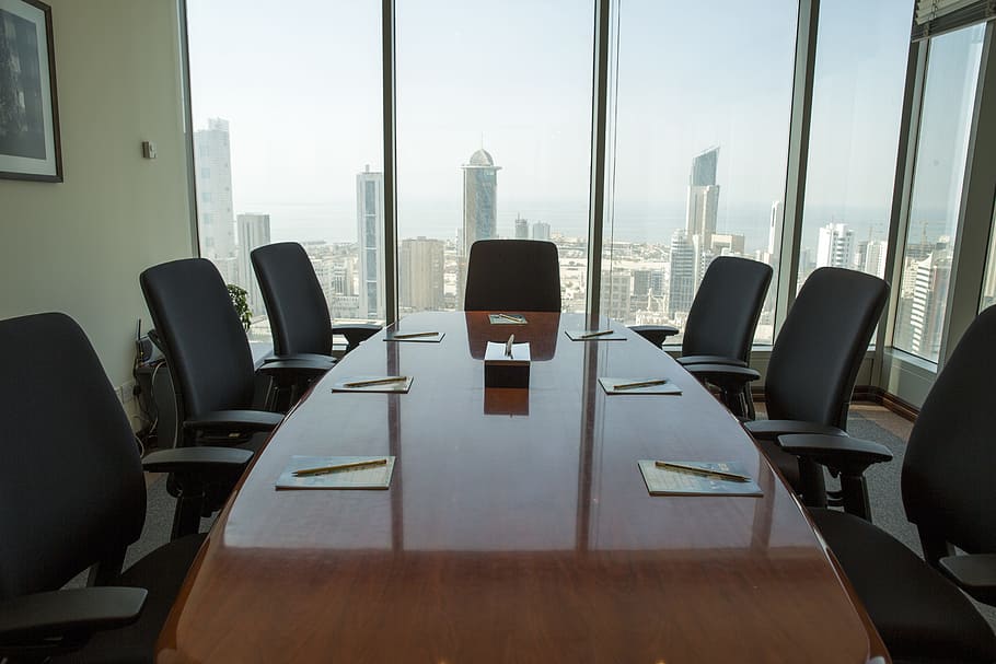 A conference table with six chairs in front of a window.